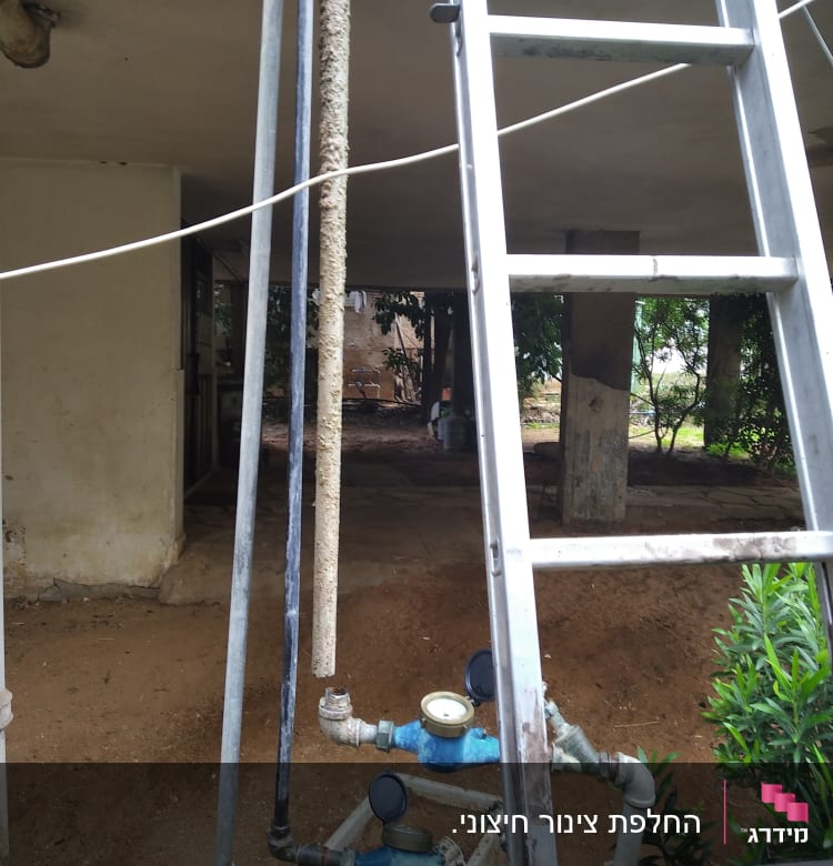 סולם ליד צינורות ומדי מים כחולים